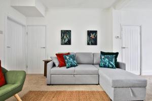 a living room with a gray couch and a green chair at Cosy 3-Bedroom House Near Caerphilly Castle in Caerphilly +20 photos