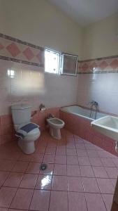 a bathroom with a toilet and a tub and a sink at Villa Albano in Delvinë