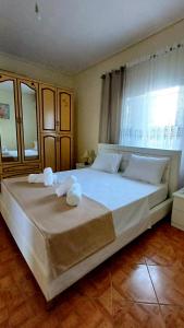 a bedroom with a large bed with towels on it at Villa Albano in Delvinë