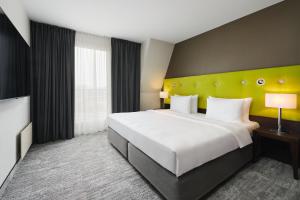 a bedroom with a large bed with a yellow headboard at Radisson Blu Sobieski in Warsaw