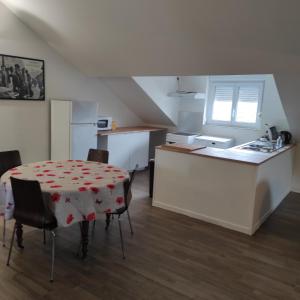 a kitchen with a table and a kitchen with a refrigerator at Grand T2 climatisé très calme in Périgueux