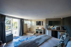 a bedroom with a large bed and a kitchen at A Stone's Throw in Grahamstown