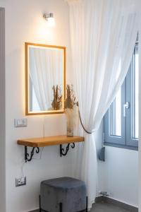 a mirror and a stool in a room with a window at Almyra House in Adamantas