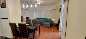 a living room with a couch and a table and chairs at Apartamento Parque dos Reis I in Monte Gordo