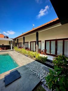 a villa with a swimming pool and a house at Plawa Bali Guest House in Canggu