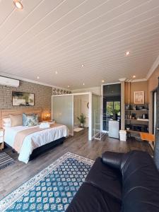 a large bedroom with a bed and a couch at Lemon & Blue Guest House in Welkom +93 photos