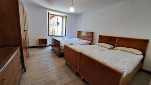 a bedroom with two beds and a window at BLACK DOLOMYTE Apartment in Schilpario