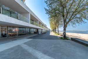 an empty sidewalk next to a building next to a beach at Douro Porto View in Vila Nova de Gaia