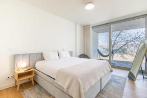 a bedroom with a bed and a large window at Douro Porto View in Vila Nova de Gaia