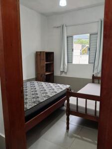 a bedroom with a bed and a window at Aparts Lesther in Ubatuba