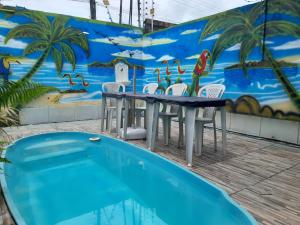 a table and chairs next to a swimming pool at Hospedagem Chapéu Virado in Belém