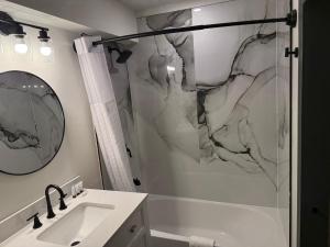 a bathroom with a shower and a sink and a mirror at Ramada by Wyndham Albany GA in Albany