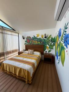 a bedroom with a bed with a painting on the wall at Cabañas Raíces del Cielo in Estorpio