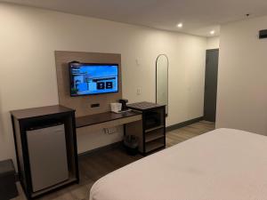 a bedroom with a bed and a tv on a wall at Ramada by Wyndham Albany GA in Albany