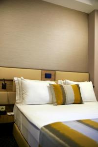 a bedroom with a bed with yellow and white pillows at Tophane Suites in Istanbul