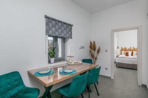 a dining room with a wooden table and green chairs at Almyra House in Adamantas +20 photos