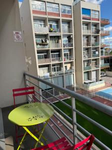 a balcony with a yellow table and chairs and a building at Villaverde light & terrace in Madrid