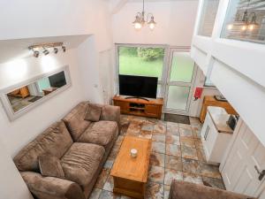 a living room with a couch and a tv at Trelessy Lodge in Amroth