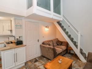 a living room with a couch and a staircase at Trelessy Lodge in Amroth