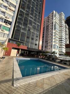 a swimming pool in front of a tall building at Flat 308 - Vista Mar in Salvador +4 photos