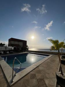 a swimming pool with the ocean in the background at Flat 308 - Vista Mar in Salvador