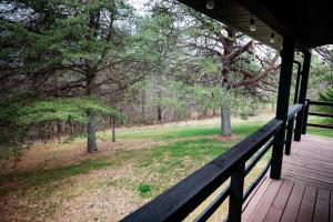 a wooden porch with a view of a field and trees at Blue Jay in South Bloomingville