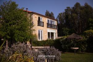 a building with an umbrella in front of a garden at Quinta Anna Horvath in Vale de Cambra