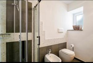 a bathroom with a toilet and a glass shower at Villa Afrodite in Mondragone +24 photos