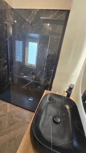 a black tub in a room with a window at Numistrano Room in Lamezia Terme +34 photos