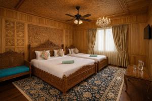 a bedroom with two beds and a ceiling fan at Imperial Group of Houseboats in Srinagar
