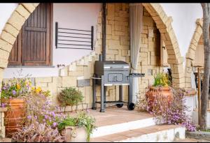 an outdoor grill outside of a house with flowers at Villa Afrodite in Mondragone