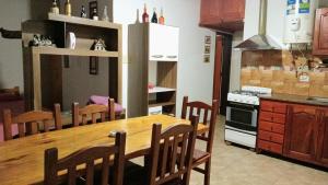 a kitchen with a wooden table and chairs in a kitchen at Complejo El Tala in Mina Clavero