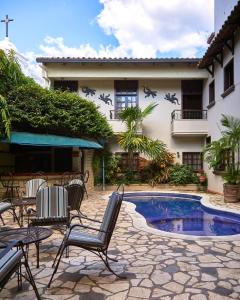 a patio with chairs and a pool in front of a building at Hotel Plaza Copan in Copán Ruinas