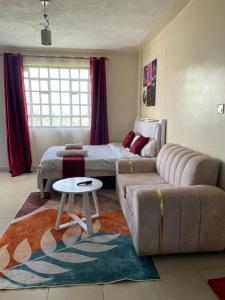 a living room with a couch and a bed at The Homely Retreat in Thika