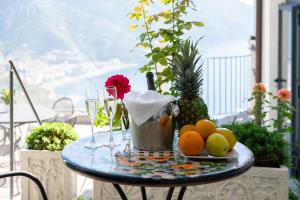 a table with fruit and wine glasses on a balcony at Villa Amore Amalfi Coast in Ravello