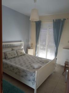 a bedroom with a white bed and a window at EFFIE'S VACATION by the sea in Kanali