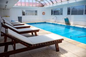 ein Swimmingpool mit einer Reihe von Liegestühlen daneben in der Unterkunft Sul Mare Hotel in Valeria del Mar