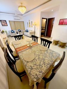 a dining table and chairs in a living room at Meera Kunj in Chhatikara