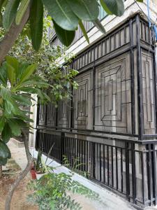 a building with a black fence in a garden at Meera Kunj in Chhatikara