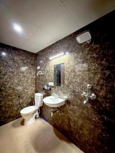 a bathroom with a toilet and a sink at Meera Kunj in Chhatikara +17 photos