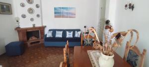 a living room with a table and a blue couch at CAPERCIA home in Forio d'Ischia