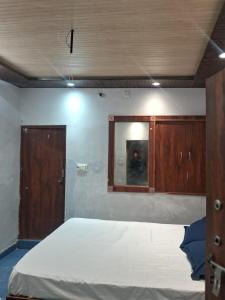a bedroom with a large bed and a mirror at Hotel Kamla Palace in Haridwār