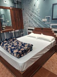 a large bed in a bedroom with a blue wall at Hotel Kamla Palace in Haridwār