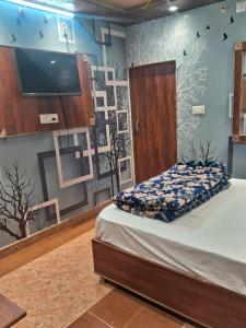 a bedroom with a bed and a flat screen tv at Hotel Kamla Palace in Haridwār