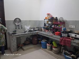 a cluttered kitchen with a sink and a counter top at SG Homestay in Amritsar