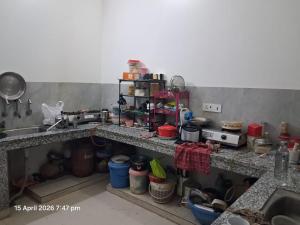 a cluttered kitchen with a counter and a sink at SG Homestay in Amritsar +1 photo