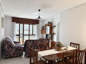 a dining room and living room with a table and a couch at Apartamento Salceda - 6901 in Noja