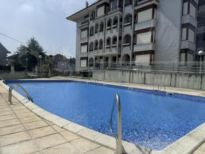 a large blue swimming pool in front of a building at Apartamento Salceda - 6901 in Noja