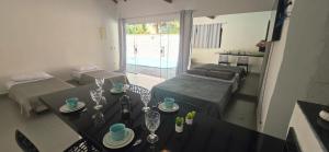 a living room with a table and a bed and a living room at Arandura Chalés maresias 04 in São Sebastião
