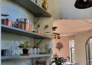 a kitchen with shelves with pots and pans at The Storybook Nook in Kaapsehoop